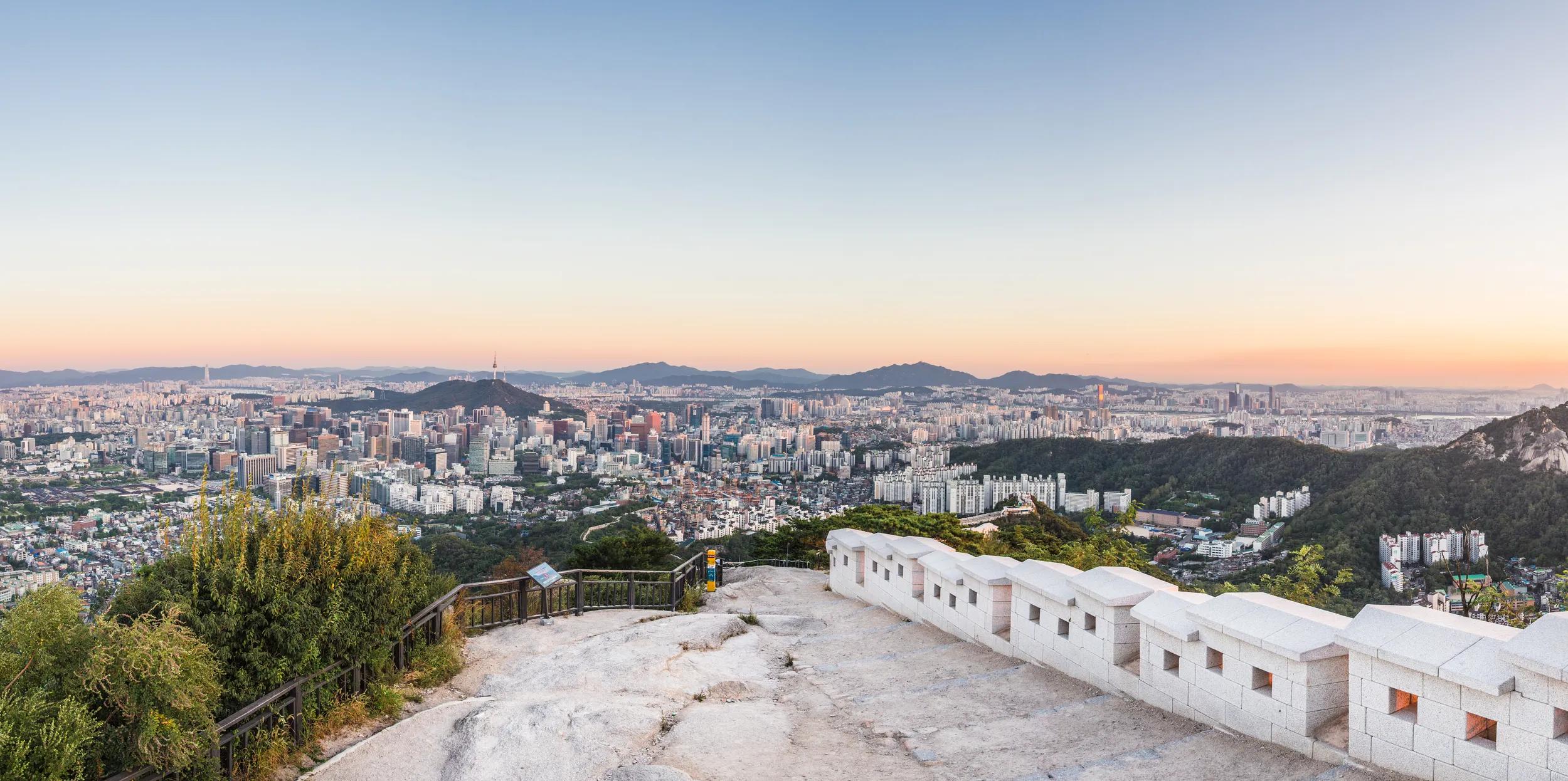 The city is spread around many hills. The wall visible are the remains of the Seoul fortress, which used to circle the entire city including the hills. A very popular hiking trail follow the wall.