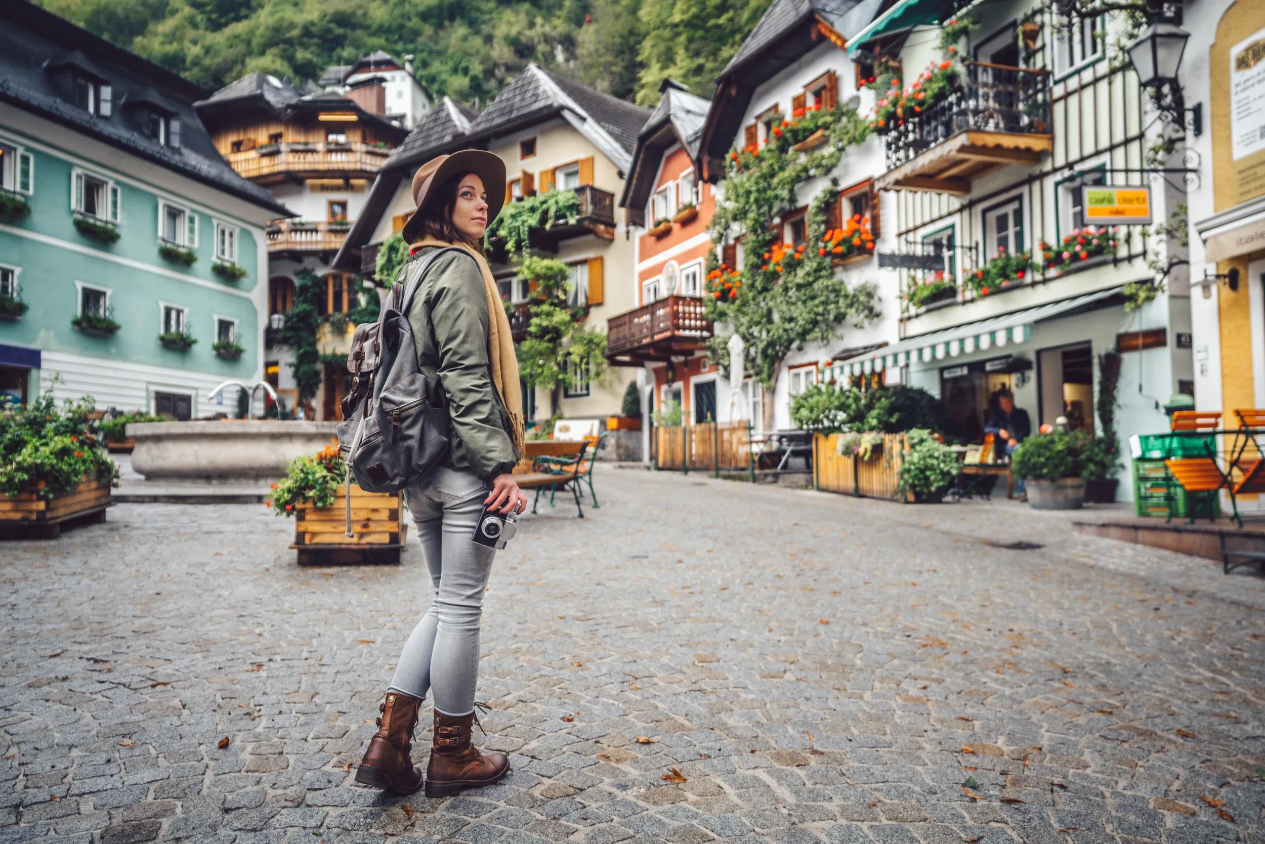 Beautiful girl with a retro camera in an alpine village