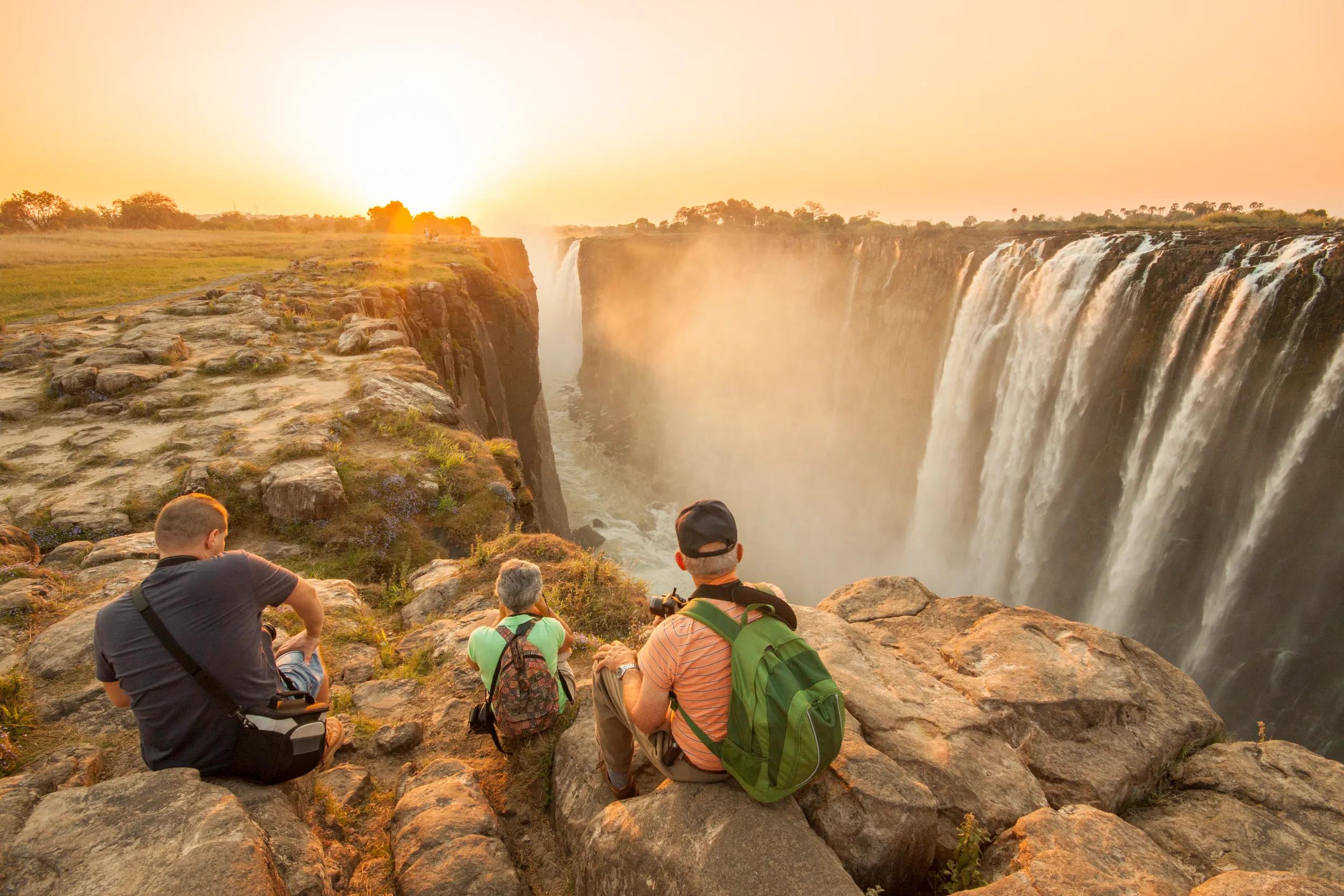 Tourists enjoying the sunset over Victoria Falls, Zimbabwe.