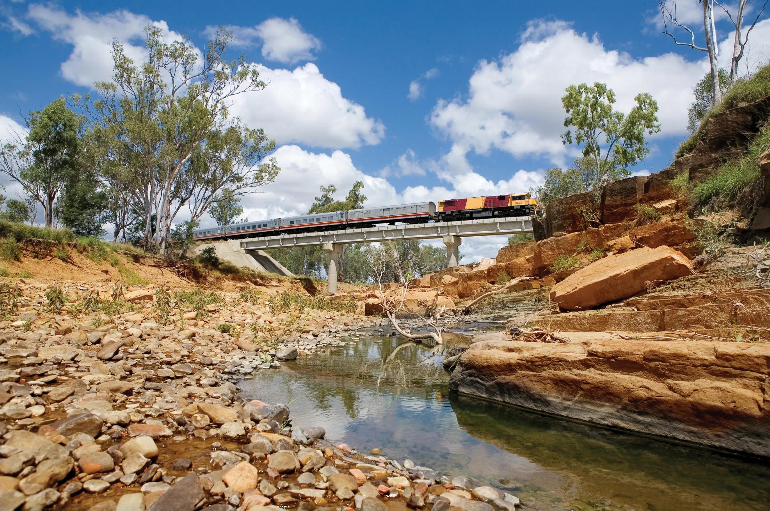 Spirit of the Outback Train crossing bridge over riverine.