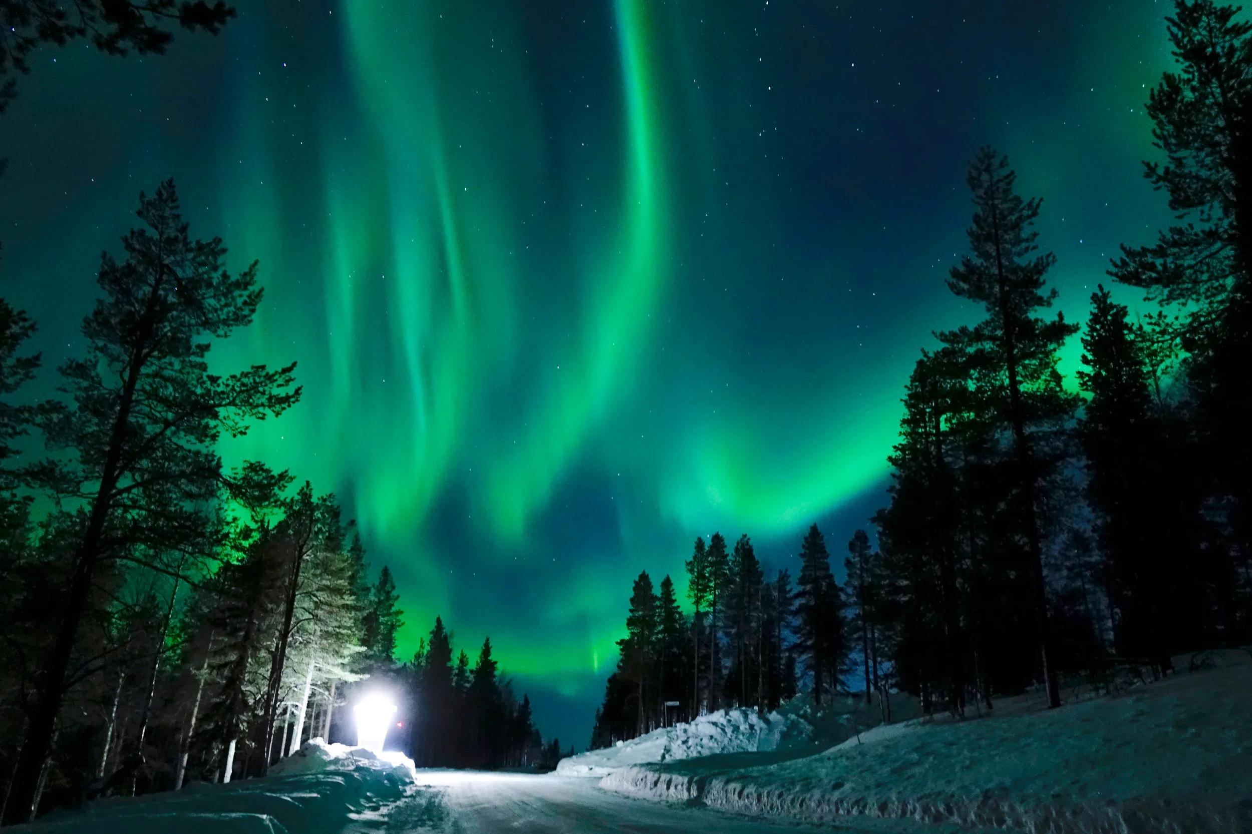 a-eu-finland-northern-lights-snowy-road-1182825543-g-rf