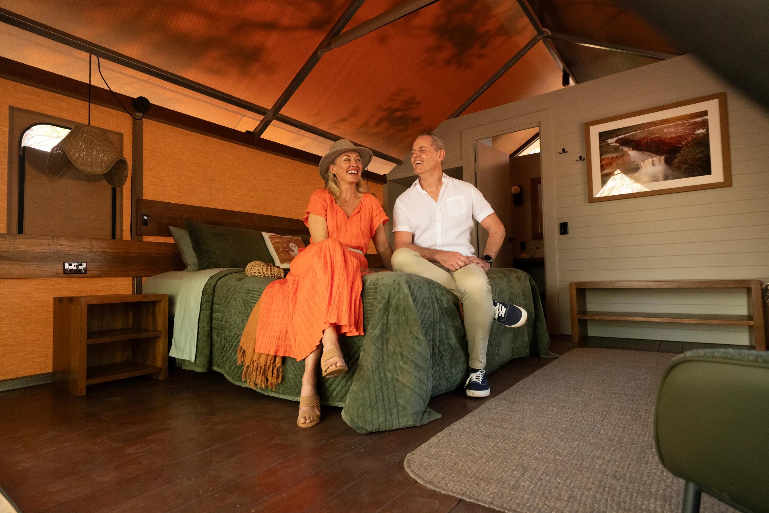 Lodge Accommodation - couple sitting on double bed - APT - Mitchell Falls photo shoot 2024.