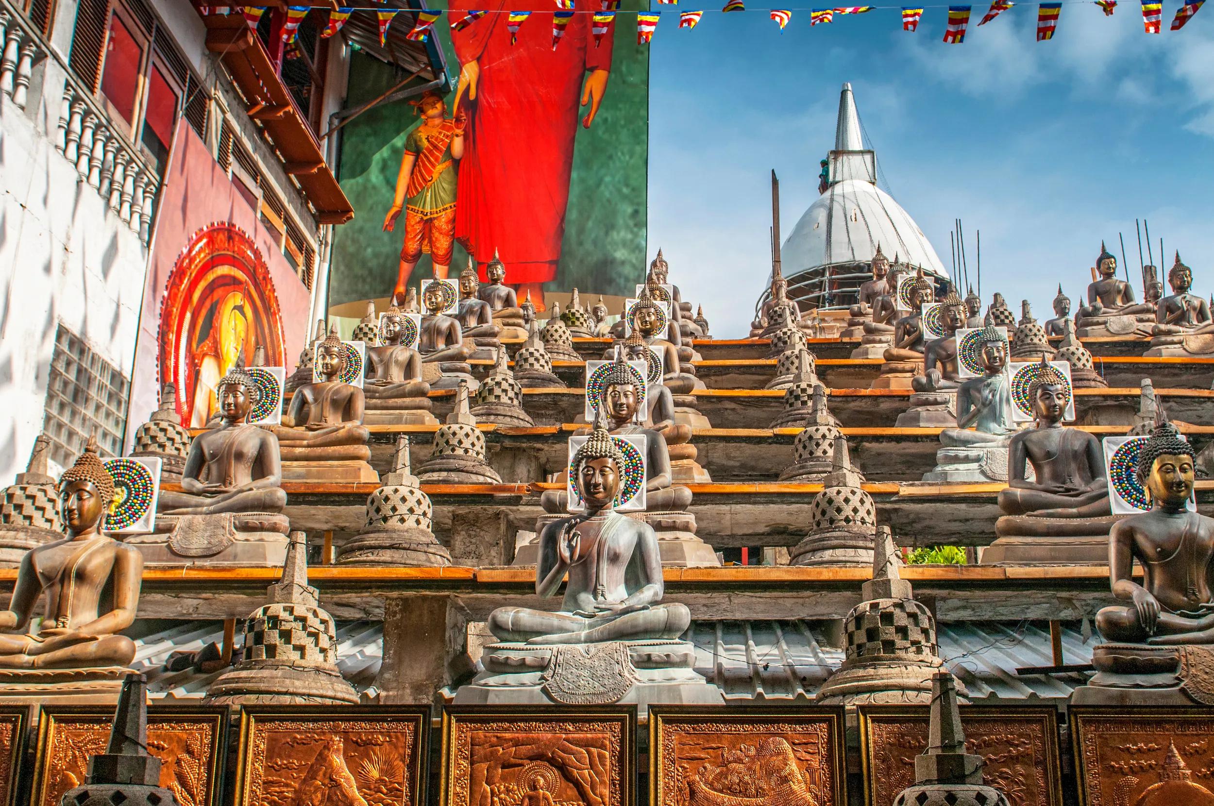 Statues of the Buddha in the lotus position, Gangaramaya Buddhist Temple, Colombo, Sri Lanka.