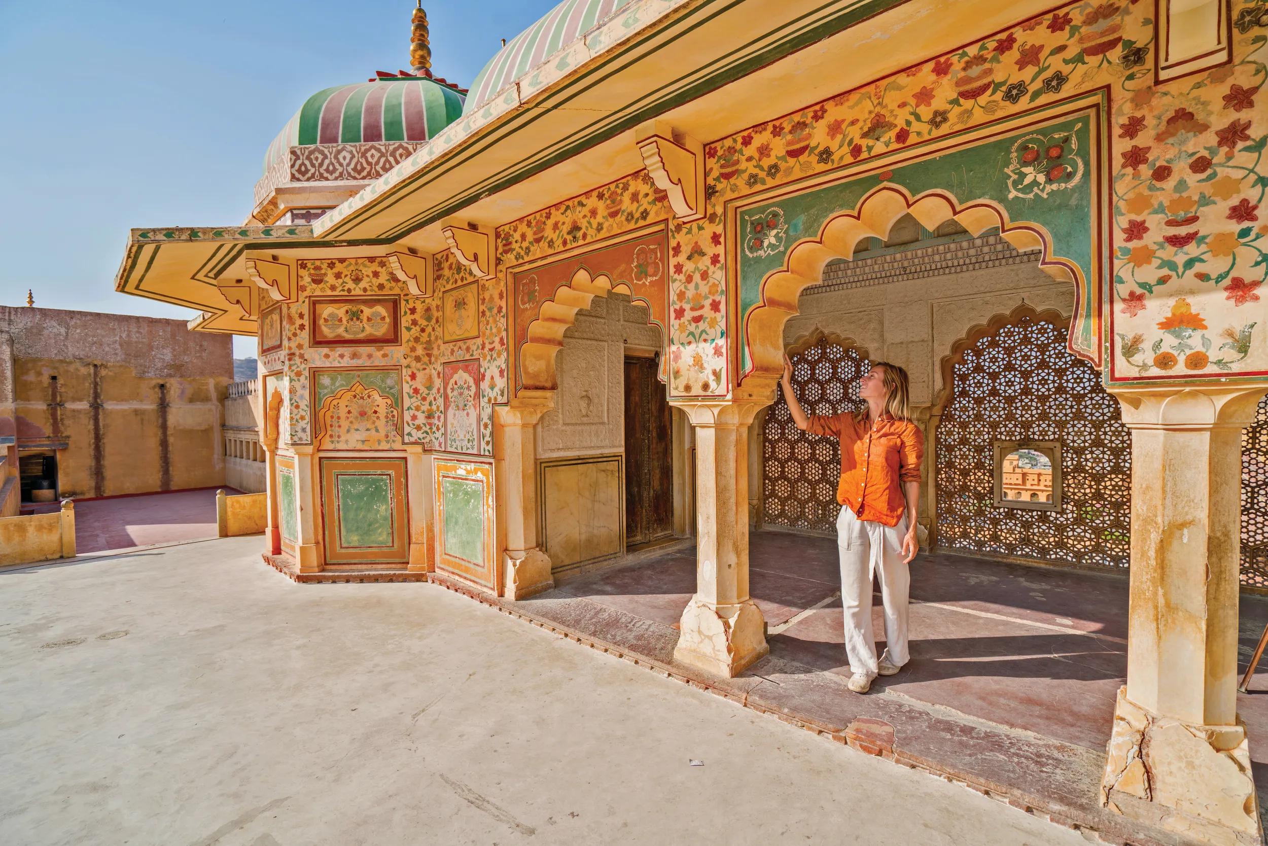 Young woman traveling in India contemplating ancient temple in Jaipur, India
